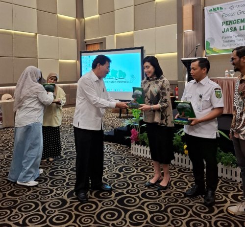 Ketua APHI Riau, Muller Tampubolon menyerahkan cinderamata.